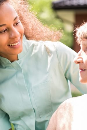 Portrait of retiree and African American nurse